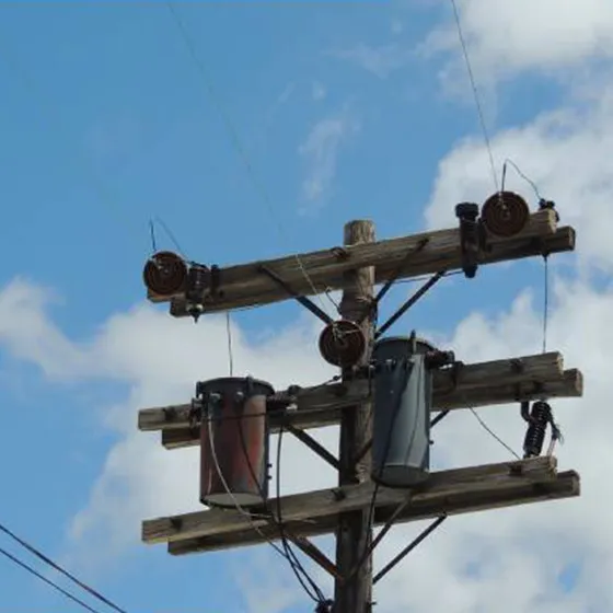 Pole-mounted oil-immersed transformer on wooden pole