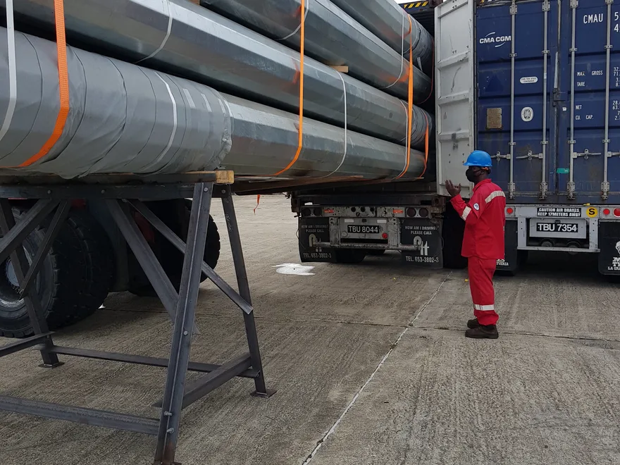 Steel transmission poles loaded for delivery to a project site